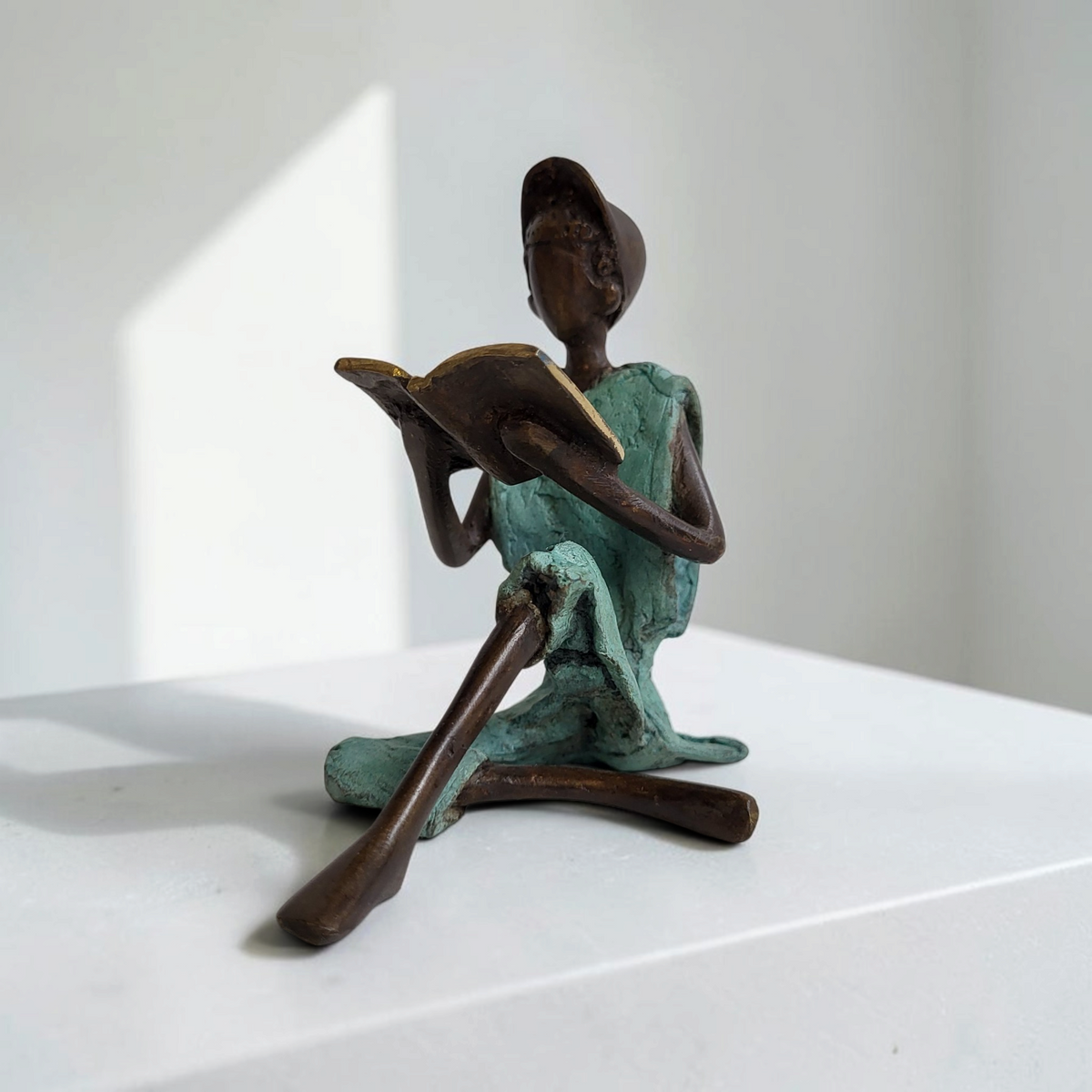 Bronze-Skulptur "Xavier" Enfant avec livre et casquette | by Souleymane