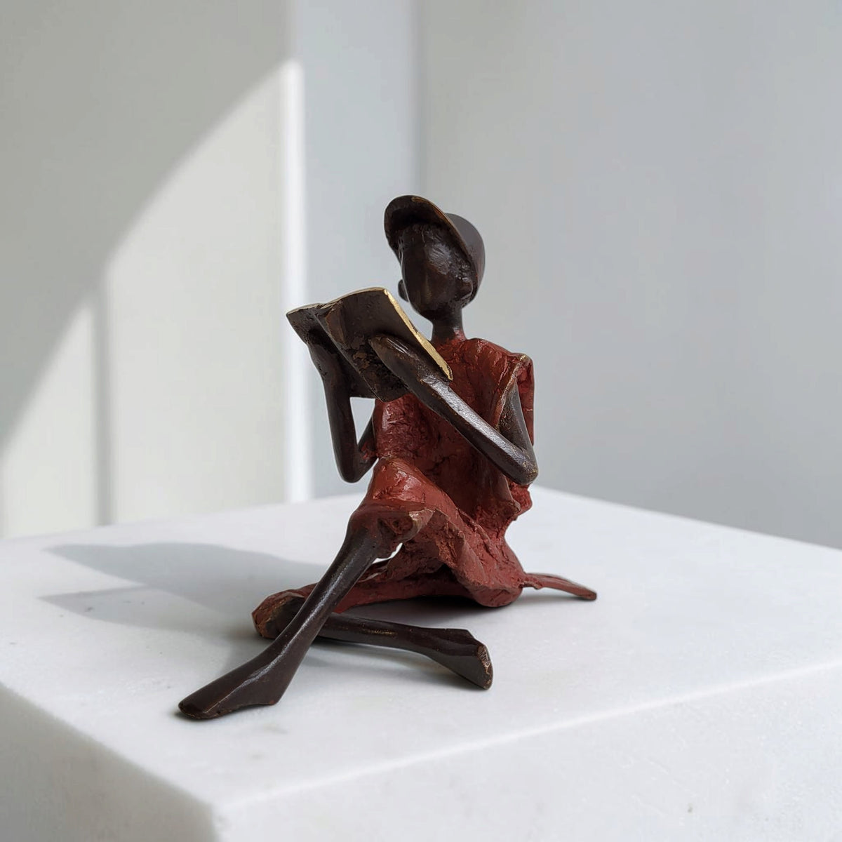 Bronze-Skulptur "Xavier" Enfant avec livre et casquette | by Souleymane