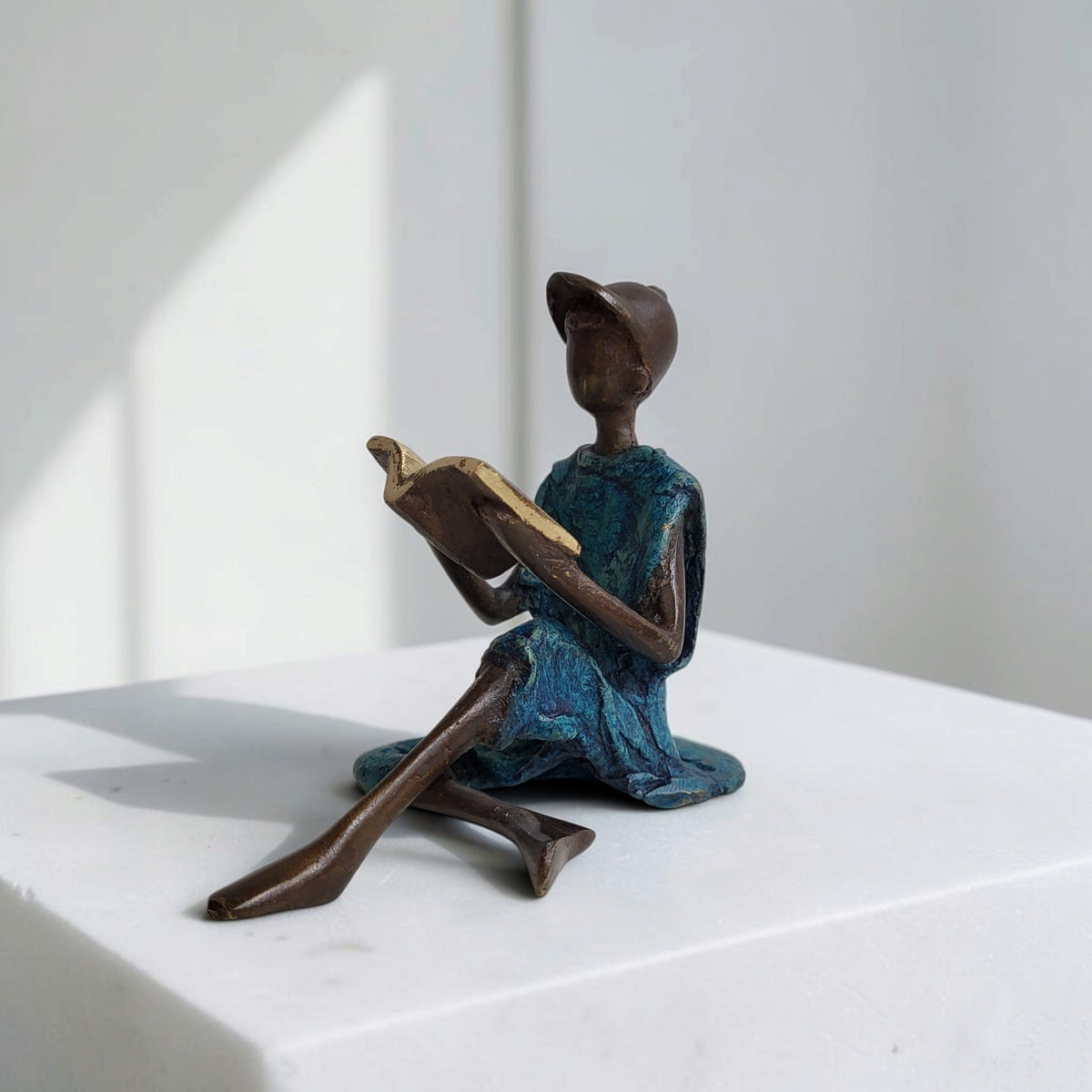 Bronze-Skulptur "Xavier" Enfant avec livre et casquette | by Souleymane