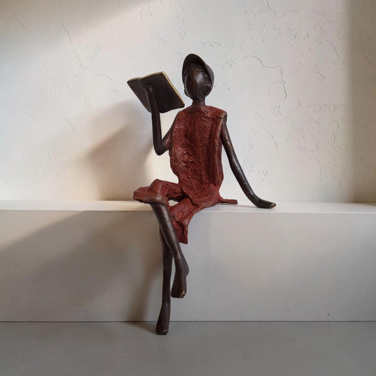 Bronze-Skulptur "Yohann" Enfant avec livre et casquette | by Souleymane