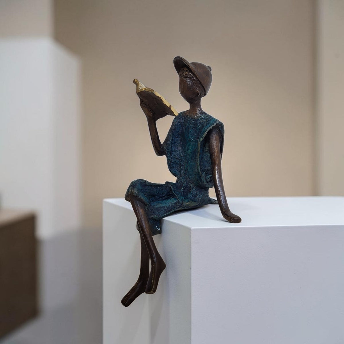 Bronze-Skulptur "Yohann" Enfant avec livre et casquette | by Souleymane