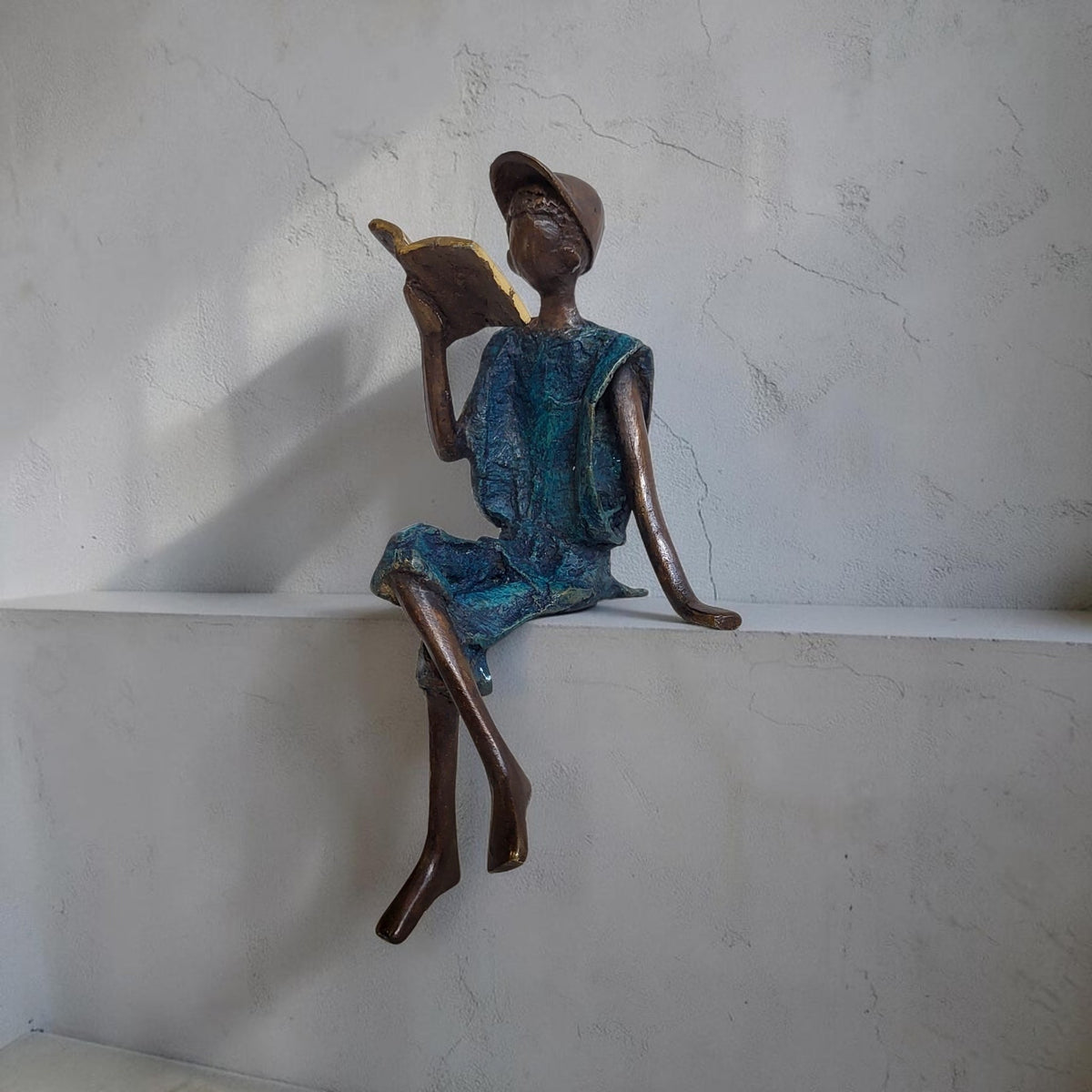Bronze-Skulptur "Yohann" Enfant avec livre et casquette | by Souleymane