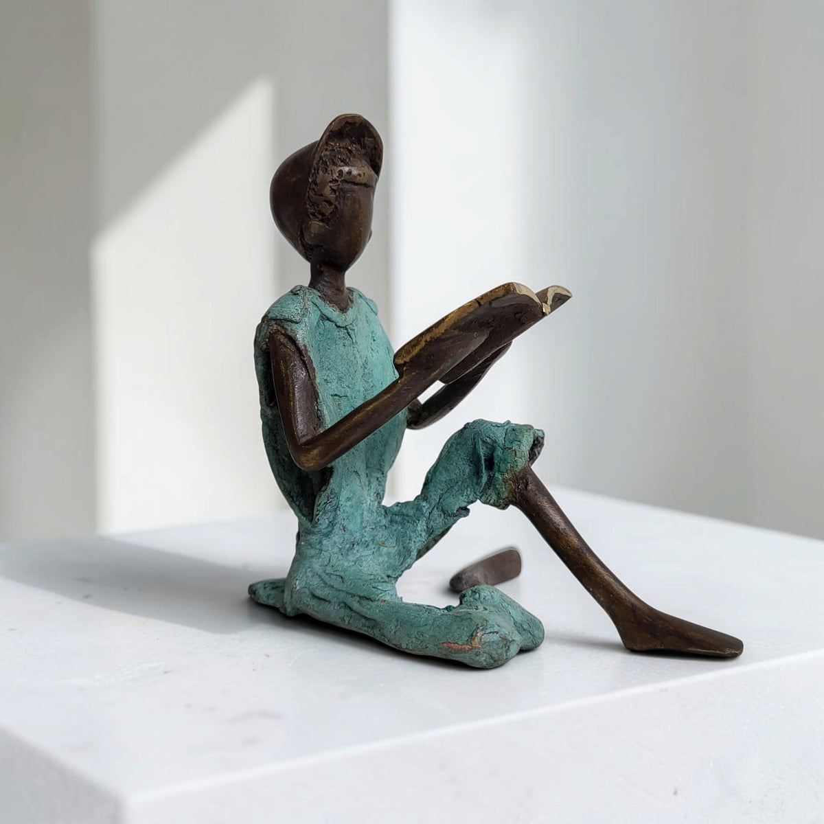 Bronze-Skulptur "Xavier" Enfant avec livre et casquette | by Souleymane